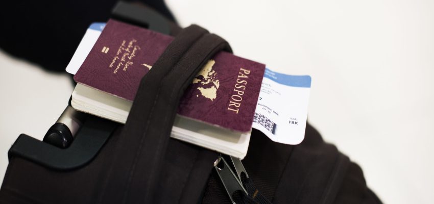 Closeup of passport with plane ticket on luggage